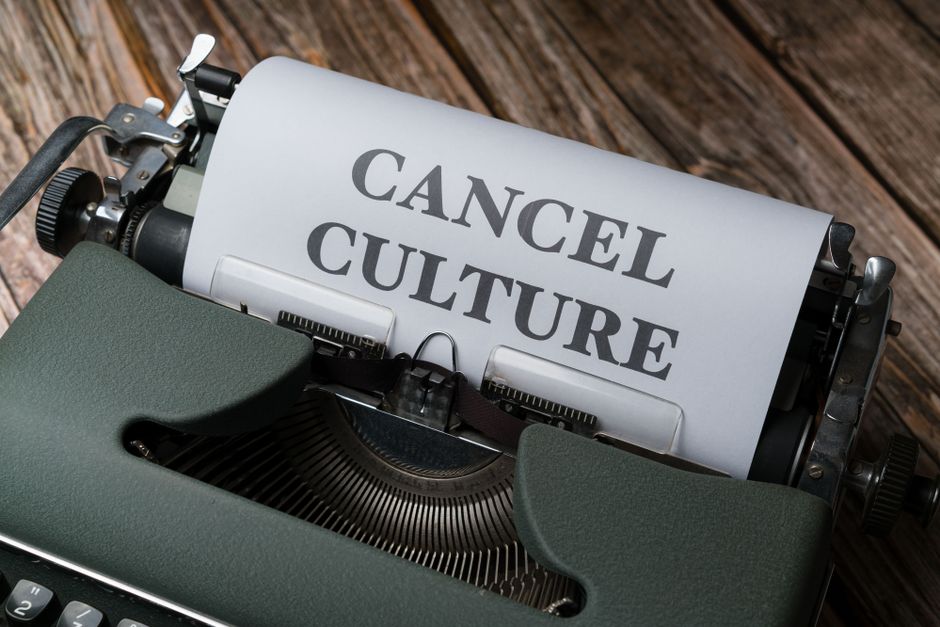 A white spiral-bound notepad with the handwritten word 'MISTAKE' in black ink is positioned on the left side of a dark surface. To the right of the notepad, there is a red rubber stamp with the word '